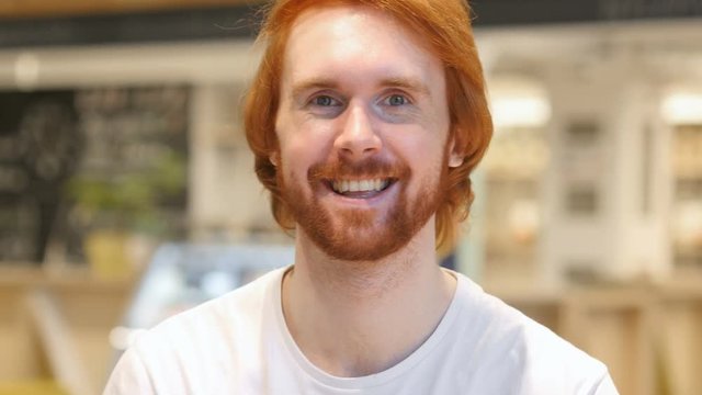 Portrait of Redhead Beard Man Gesturing Okay Sign in Cafe