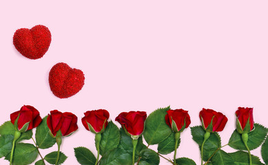 Red roses and red hearts on a pink background with space for text. Top view, flat lay. Valentine decoration.