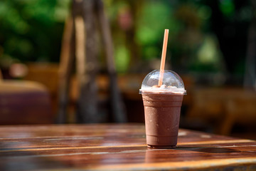 Ice coffee plastic glass on the table in coffee shop
