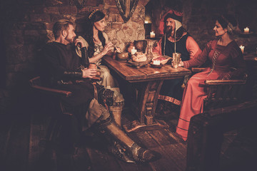 Medieval people eat and drink in ancient castle tavern