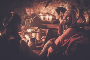 Medieval people eat and drink in ancient castle tavern