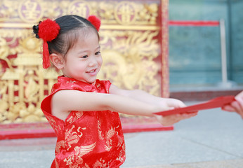 Happy little Asian girl received a red envelope. Chinese New Year celebration.