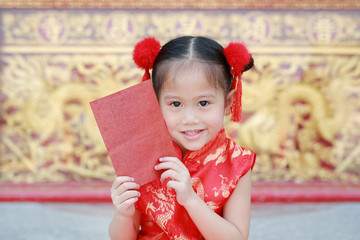 Happy chinese new year festival. smiling little Asian girl holding red envelope.