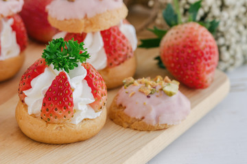 Strawberry choux cream. Combination with choux pastry whipped cream fresh strawberries glaze with white chocolate and chopped pistachios. Sweet and delicious dessert for Valentine. Homemade bakery.