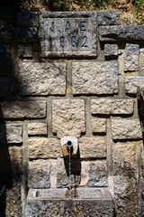 Stone drinking fountain dated 1962 in the Serra de Monchique, Algarve, Portugal.