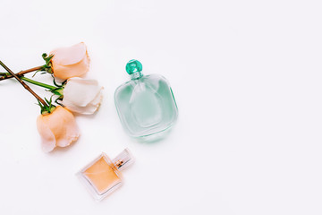 Beauty composition with flowers of roses and perfume in pastel pink colours on a white background