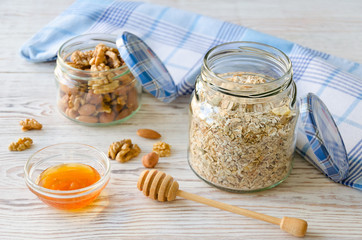 Mason jar with mixed muesli, variety of nuts and honey