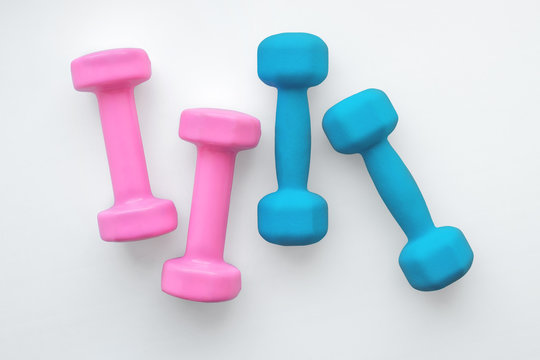 two pairs of dumbbells blue and pink on white
