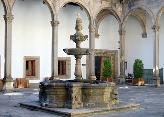 Fountain in the interior courtyard of the Hostal de los Reyes Catolicos built in 1499 as a hospital for sick pilgrims - Santiago de Compostela, Galicia, Spain