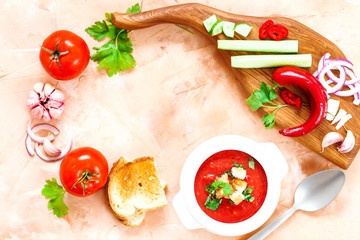 Fresh, healthy tomato soup with basil, pepper, garlic, tomatoes and bread on wooden background. Spanish gazpacho soup. Top view. Copy space