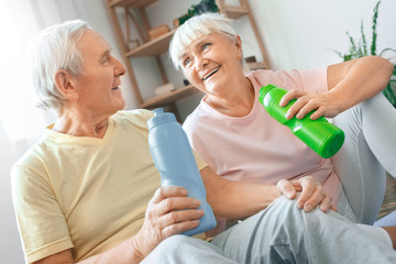 Senior couple exercise together at home health care drinking water refreshment