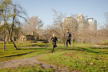 Fototapeta premium couple of young runners training inautumn park 