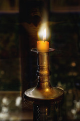 Close view of  burning candle with a candlestick