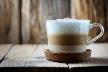 coffee Cup on wooden table with cork stand. three-layered coffee