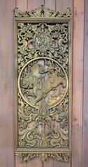 An ancient mural wood carving on wood wall thailand.