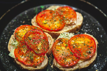 Three bruschettes with tomatoes lie on plate