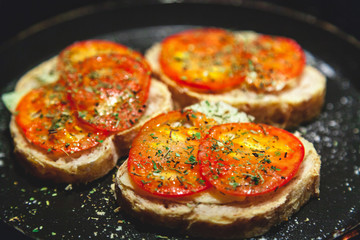 Three bruschettes with tomatoes lie on plate