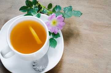 Cup of morning tea with lemon and delicate flowers