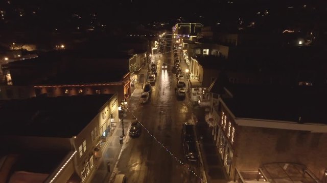 Aerial ascending shot of cars in cool mountain town on a winter night