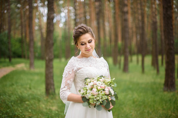 Obraz na płótnie Canvas Adorable young beautiful bride with bouquet in hands.