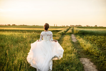 Happy and beautiful bride dance alone in nature