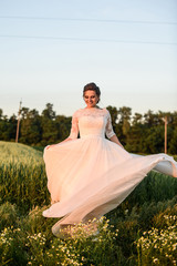 Fototapeta premium Happy and beautiful bride dance alone in nature