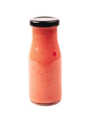 Red sauce in a glass bottle isolated