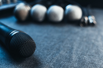 Obraz premium Gray on the table are microphones next to the remote, all on a black background