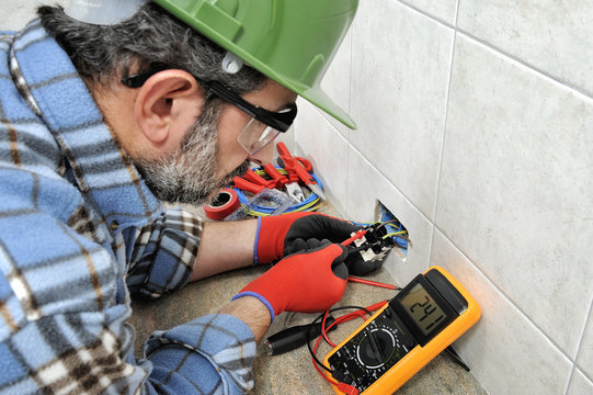 Electrician technician working safely on a residential electrical system.