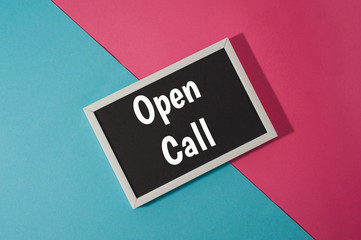 Open call - text on chalkboard on blue and pink bright background.