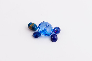five blue beads of different shapes used to create jewelry