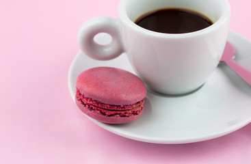 Cappuccino espresso coffee on a pink background with french macaroons or macaron cookies