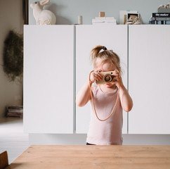 Kleines Mädchen fotografiert und spielt in seinem Zimmer