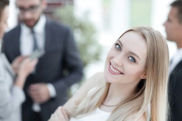 Fototapeta premium close-up of a young woman in the office on the background of colleagues.