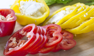 Slice color pepper on cutting board. 