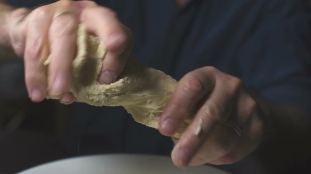 Farmer whacks the dough over a large bowl. Video