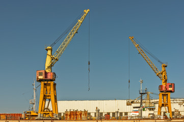 Fototapeta na wymiar Two cranes on port pier