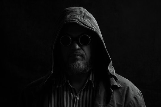 dark portrait of a man in a hood