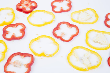 Red and yellow sweet pepper slices isolated on white background