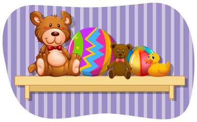 Teddybears and balls on wooden shelf