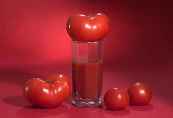 Juicy mature tomatoes on a red background