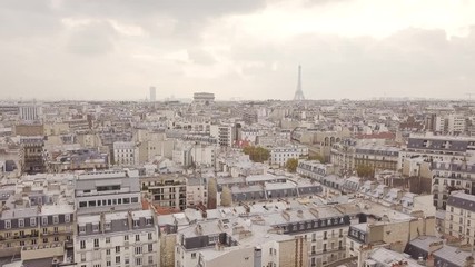Flying above roofs of Paris in cloudy weather