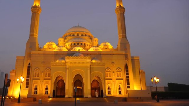 Arab man in thawb leaves the mosque. Imam or mullah in kandura comes out of the mosque.