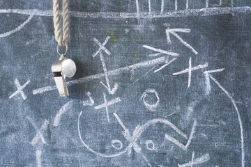 whistle of a soccer or football referee / coach on black board with tactical diagram