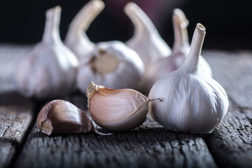 Organic garlic whole and cloves on the wooden background