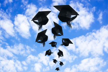 Graduation day, Images of graduation Caps or hat throwing in the air with sunshine day on blue sky background, Happiness feeling, Commencement day, Congratulation, Ceremony