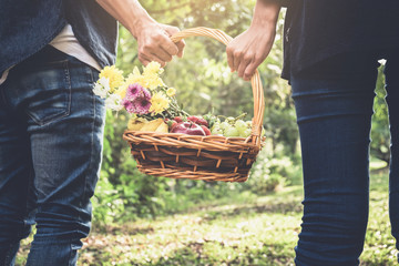 Couple in love walking and holding a picnic basket on nature outdoor background