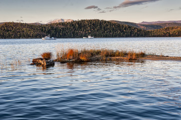 the lake with blue water and two ships in the fall