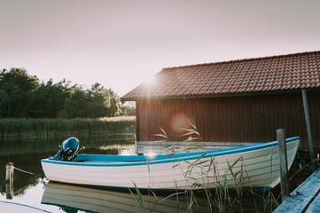 Fototapeta na wymiar Boot am Bootshaus in Schweden an der Küste in der Abendsonne