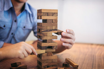 Images of hand of businesspeople placing and pulling wood block on the tower, Alternative risk concept, plan and strategy in business, Risk To Make Business Growth Concept With Wooden Blocks